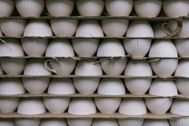 a bunch of large white vases on shelves