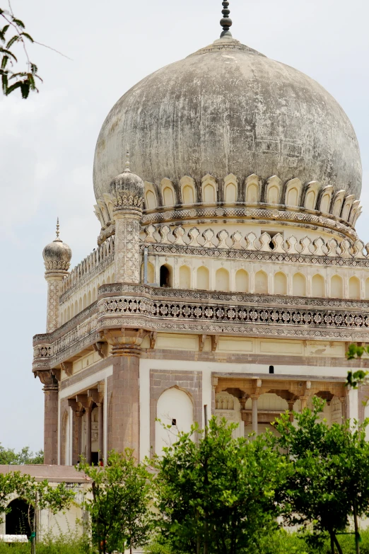 a white and tan ornate building surrounded by trees