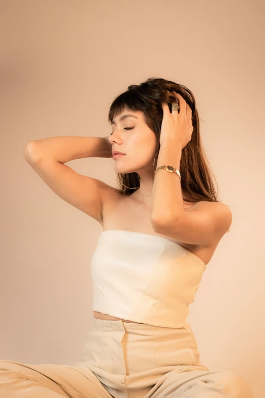 a girl in white clothes sits on top of a bed