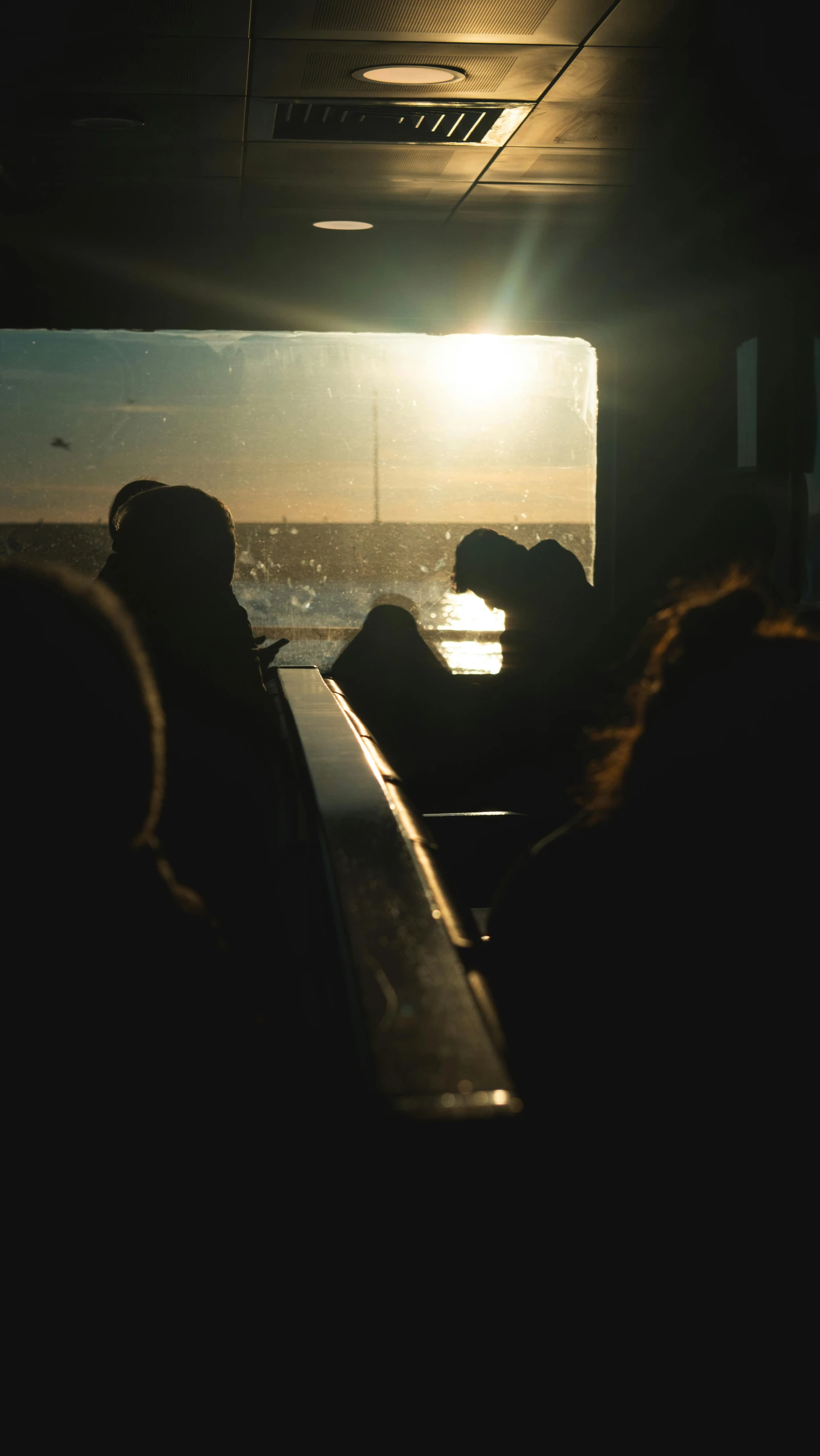 people sit in a boat as the sun is setting