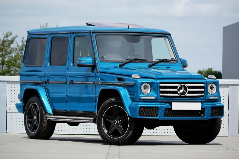 a bright blue mercedes benz g class has an impressive stance and style