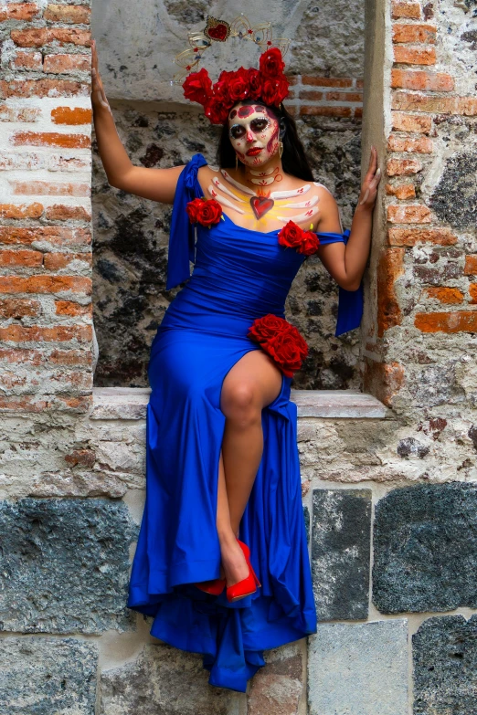 the woman wearing red rose decorations is dressed in a blue dress