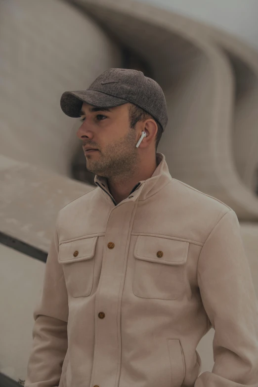 a man wearing ear buds stands in front of a boat