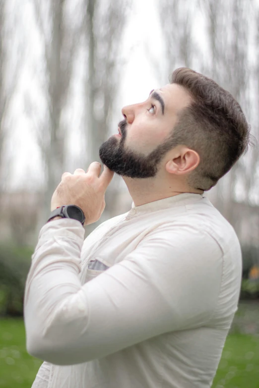 a man with a beard standing in the grass