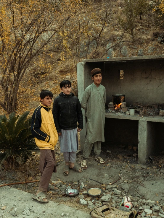 three children standing in front of a concrete stove