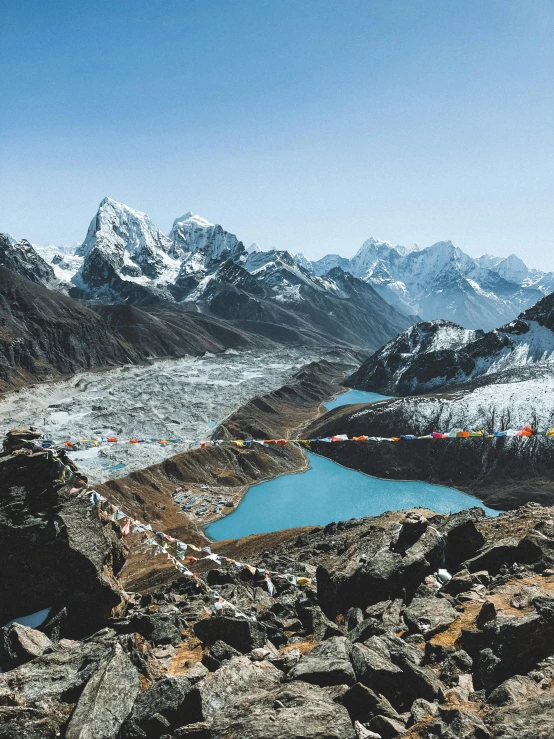 a blue lake surrounded by snow covered mountains