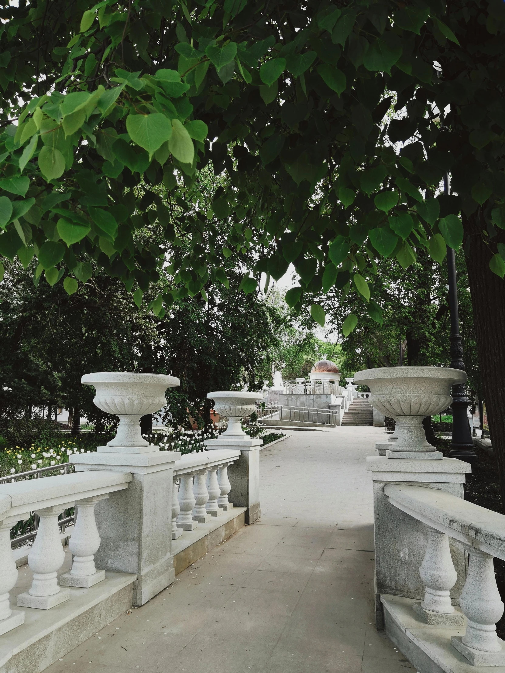 a walkway with vases lined up against the railing