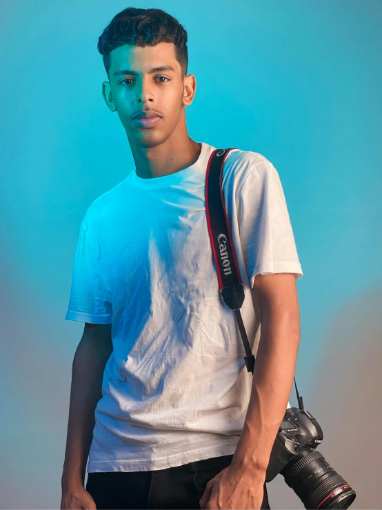 a young man poses for a po with his camera