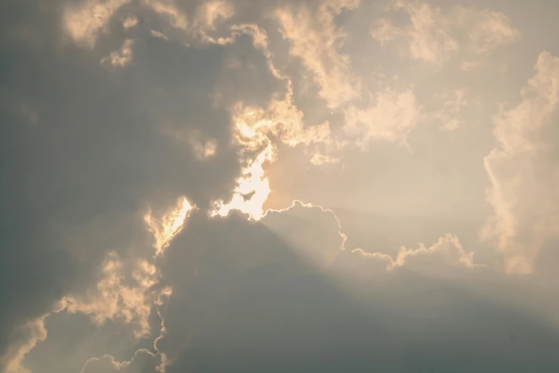 the sun shining through dark clouds in front of some white