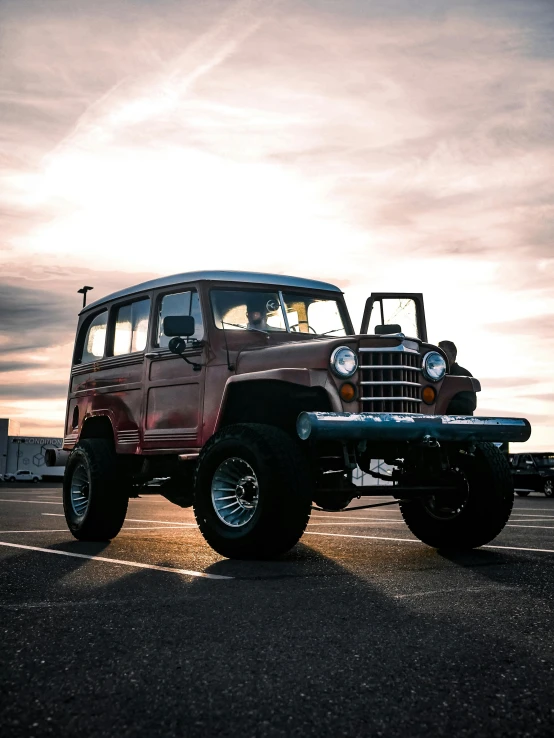 a red jeep is parked in a parking lot