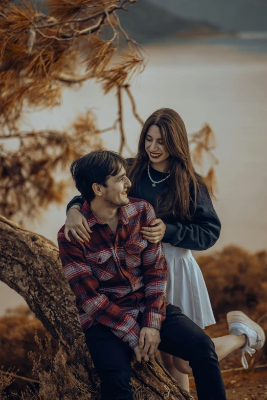 an image of a man and woman emcing on a tree nch