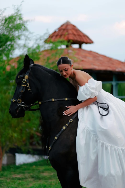 a bride is hugging her black horse outside