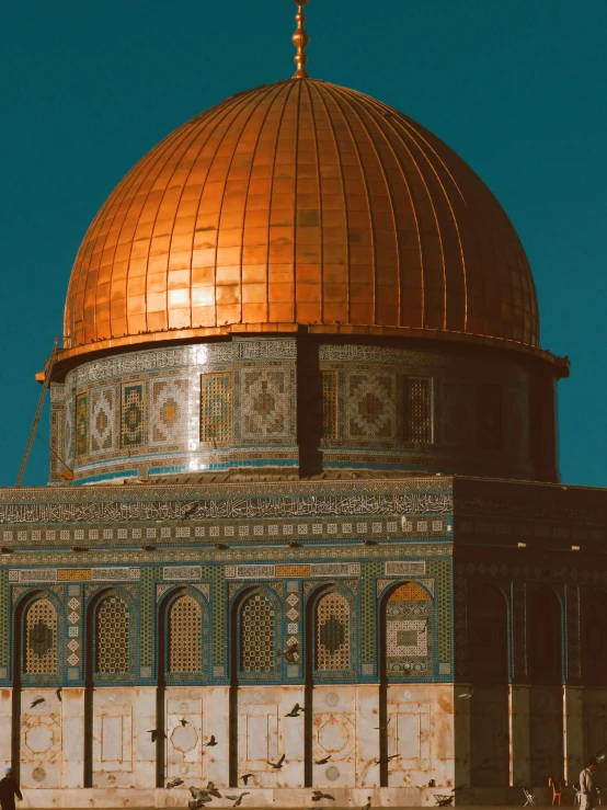 a view of a golden dome structure near people on the street