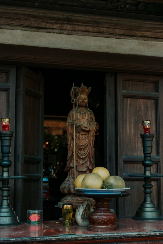 a tray of fruit is displayed outside a temple