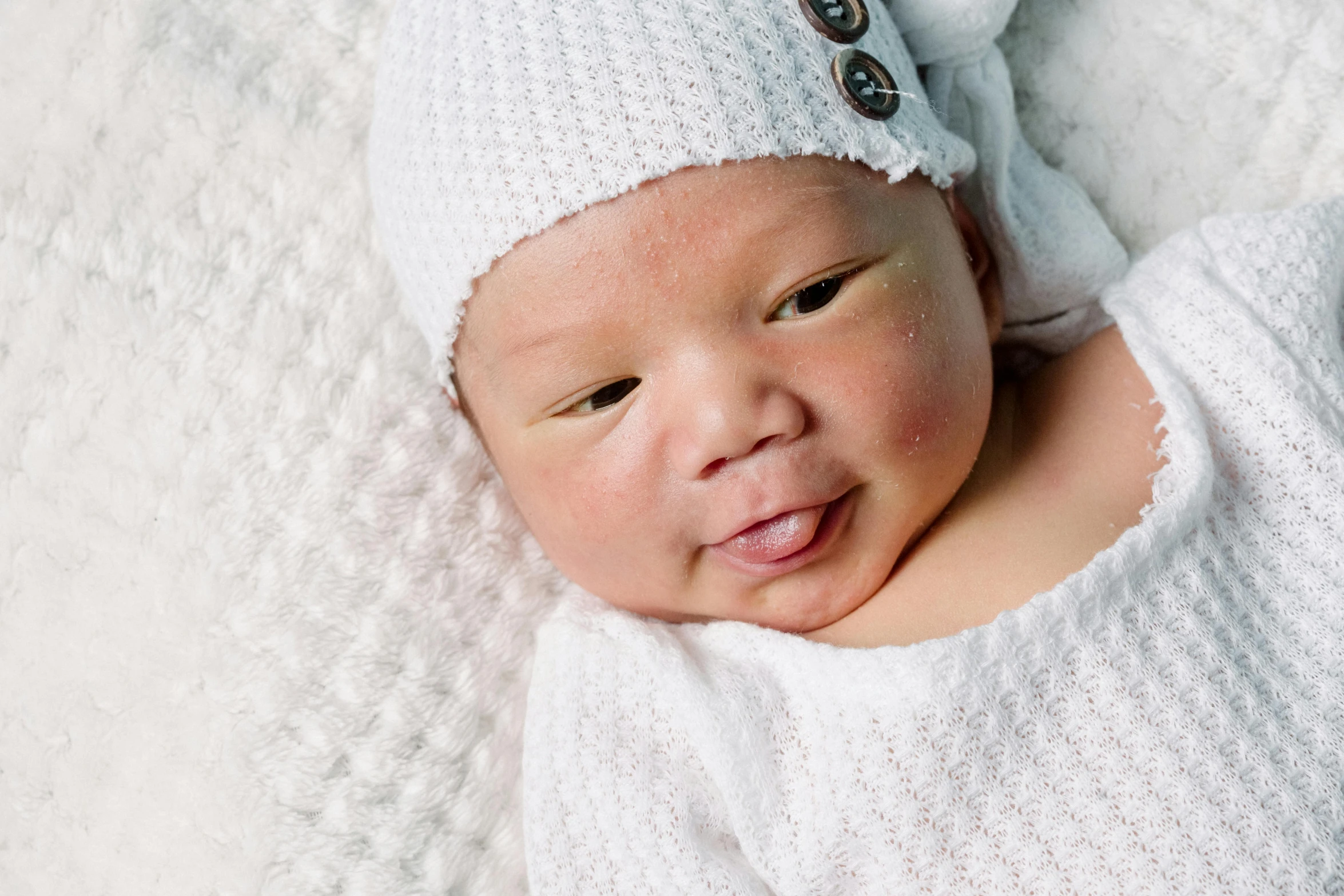 the newborn baby is wearing a white knitted outfit