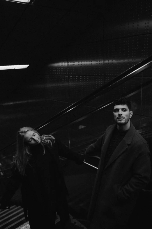 the man and woman are standing together by the stairs