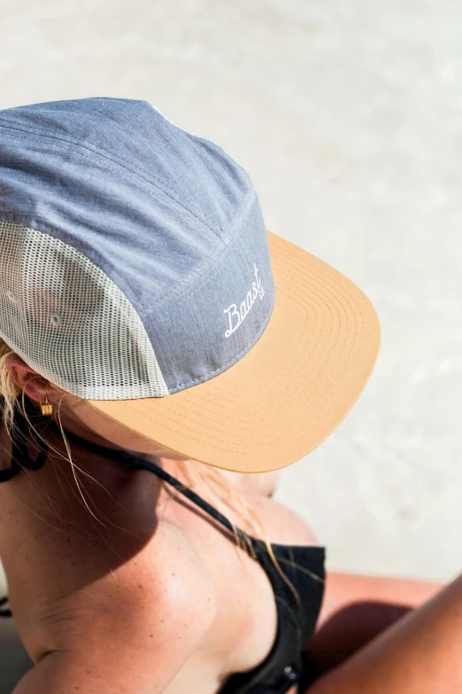 woman with sun hat looking out over white beach