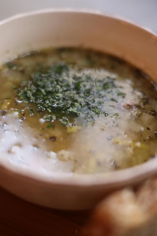 a bowl of soup with herbs in it