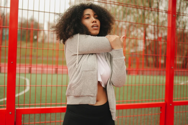 a beautiful woman in tights standing in front of red gates