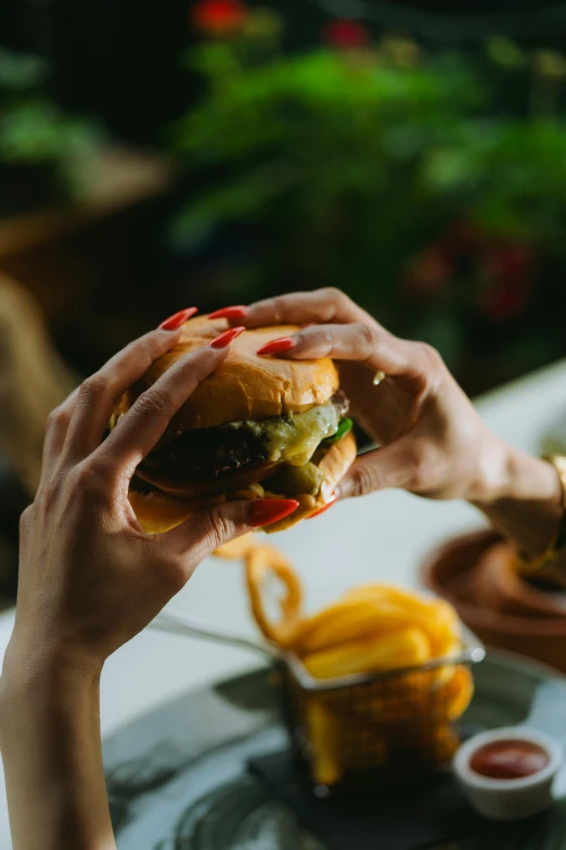 two hands are holding up a sandwich and dipping sauce