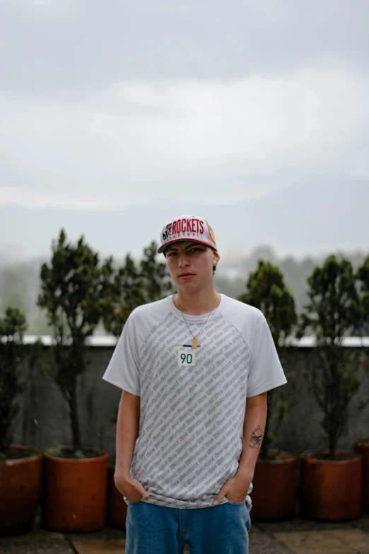 a man with sunglasses and a baseball cap poses for the camera