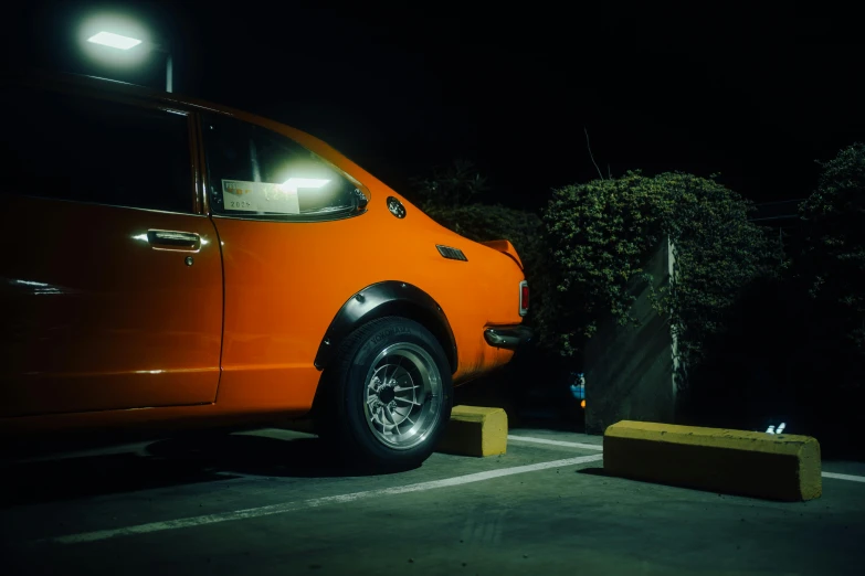 an orange truck sitting in a parking space at night