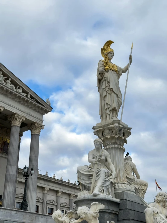 a statue on top of a marble fountain in front of a building