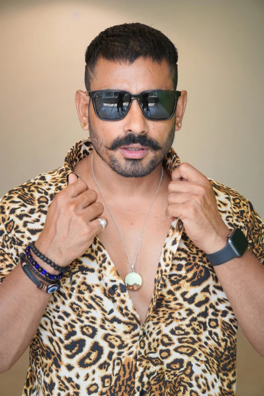 a man wearing sunglasses with a jewelry around his neck