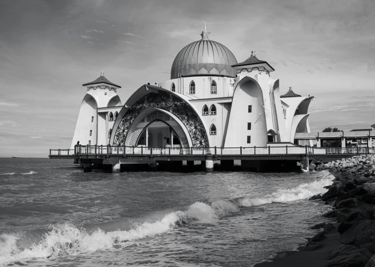 a building sits out on the shore in a black and white po