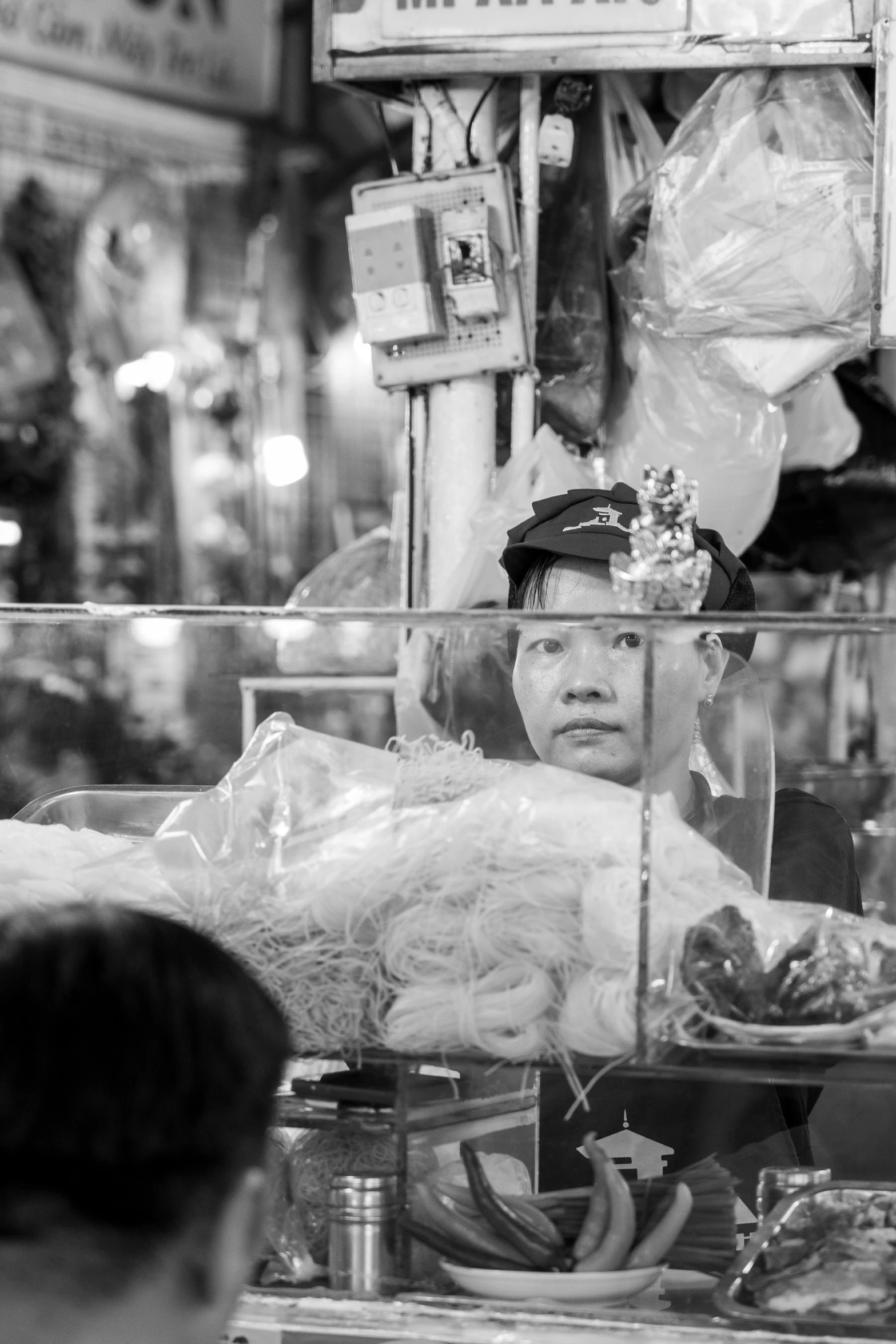 an asian shopkeeper at a grocery store selling items