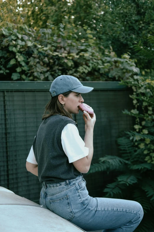 a woman is sitting down while eating an doughnut