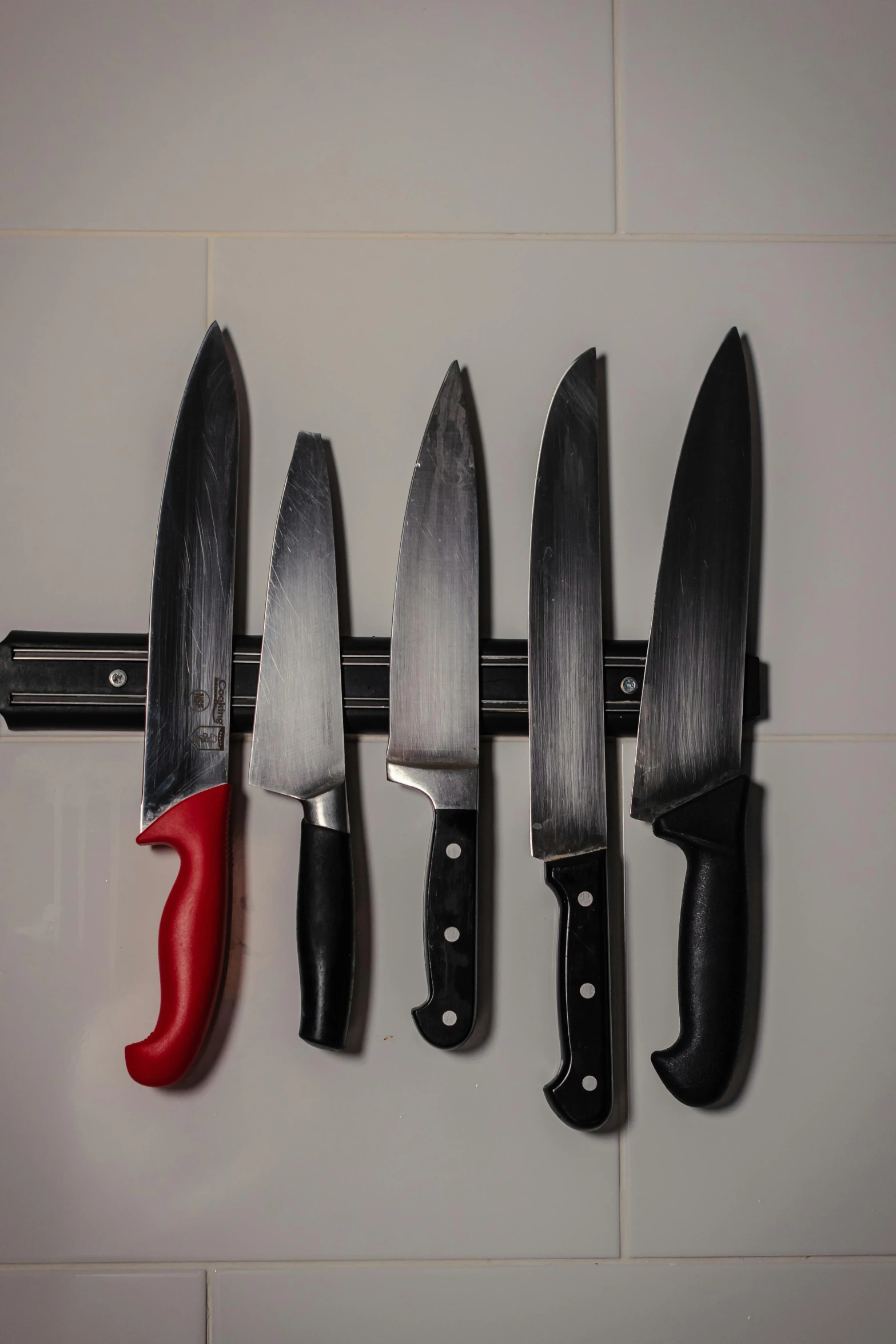 knifes are hung up on the wall by the knives