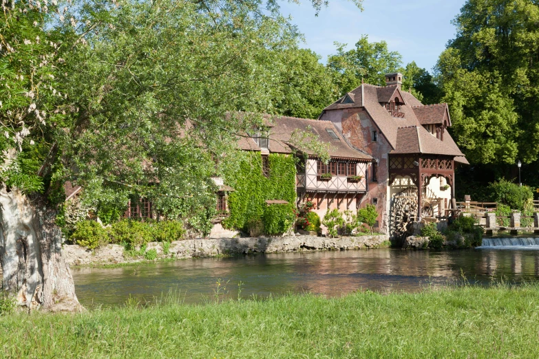 a small, old house is next to a river