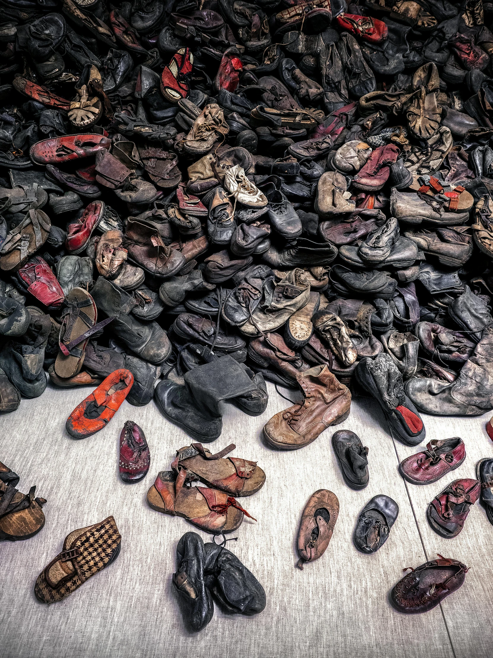 assorted shoes and bags on the floor next to each other