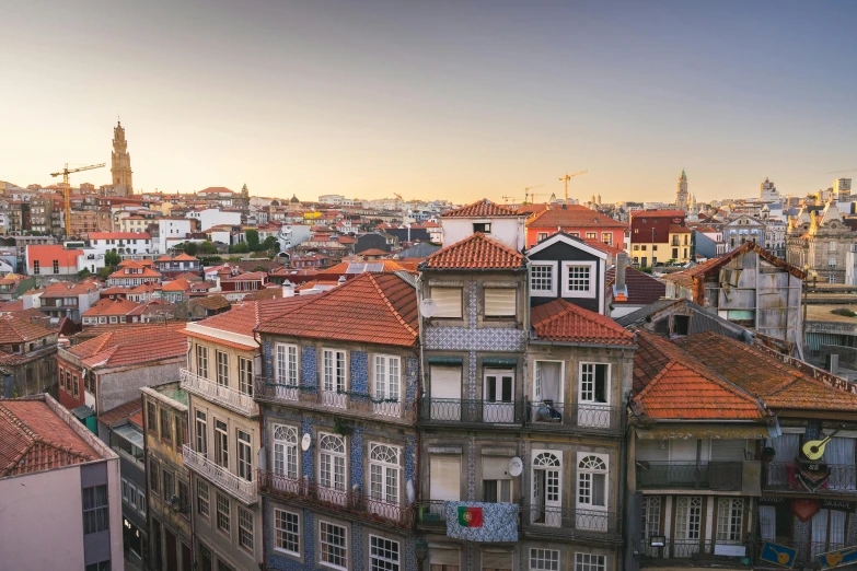 view of a city with buildings and rooftops at sunset