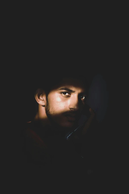 man talking on a phone in the dark