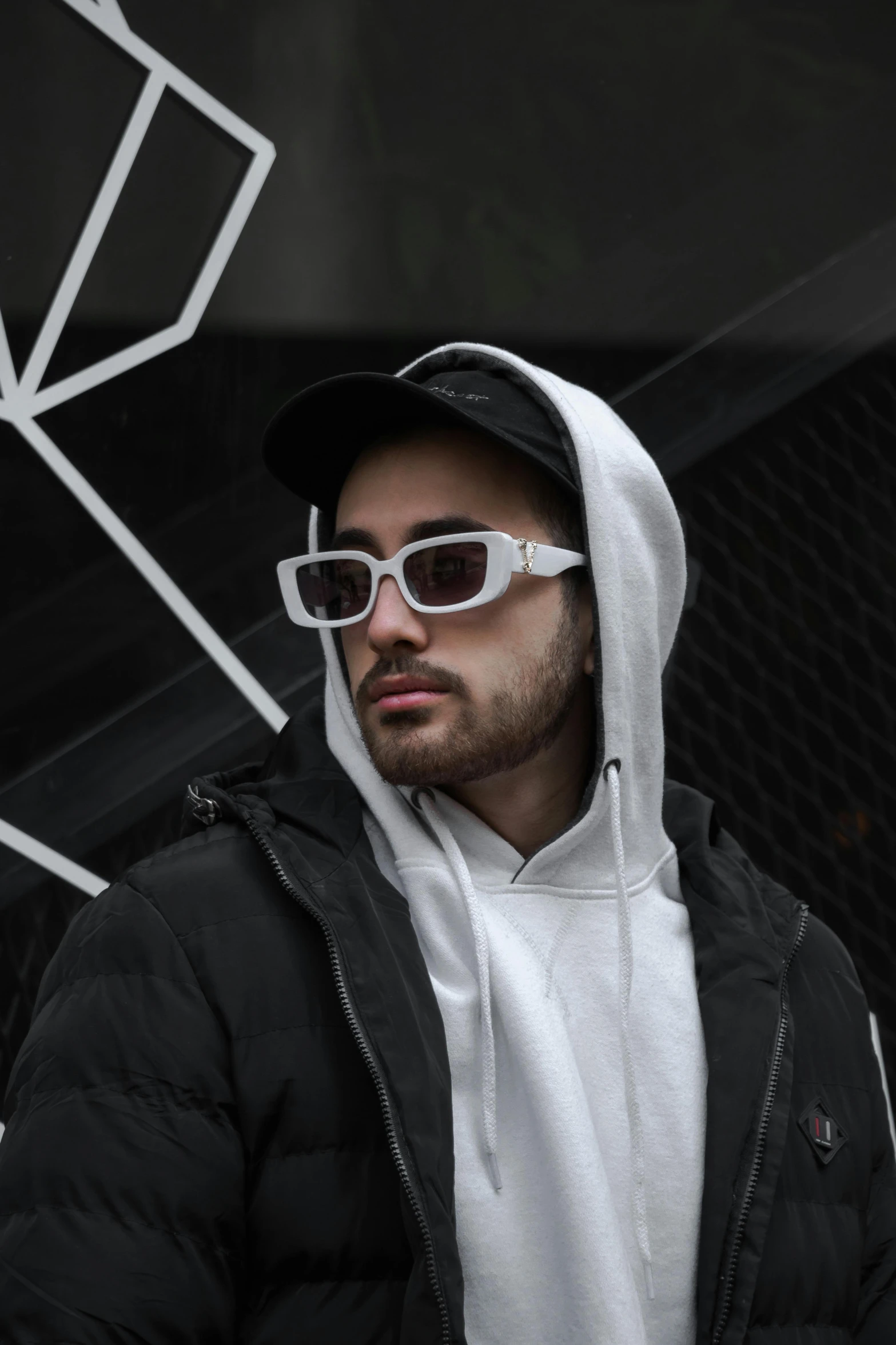 man in a hoodie and white glasses staring ahead