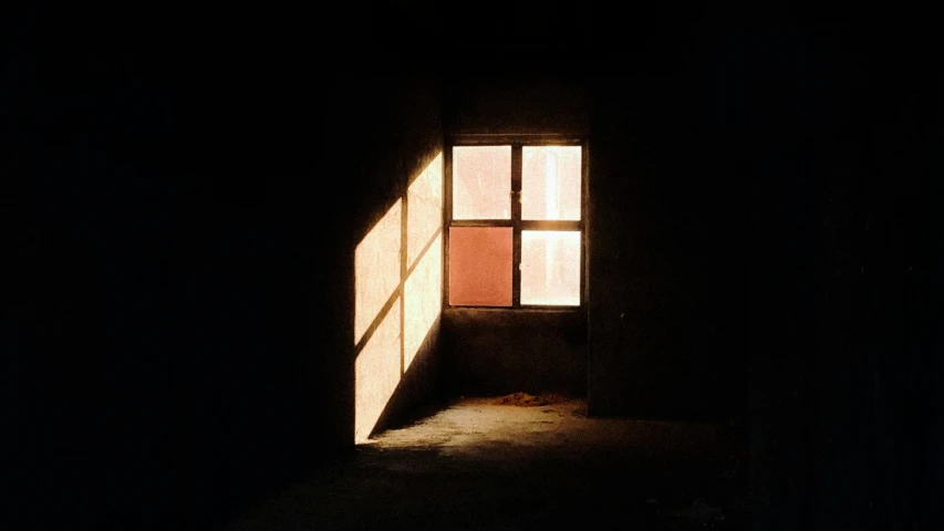 light shining in from an open window on a dark building