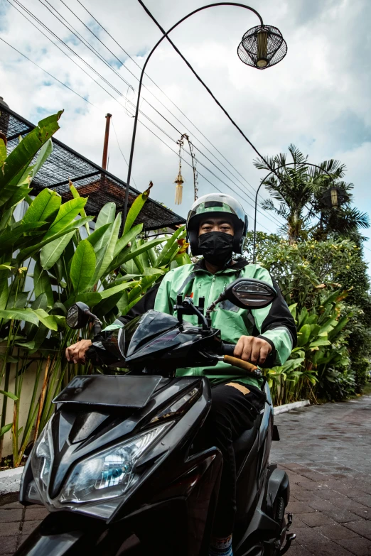 a person on a small motorcycle is parked on the side of the street