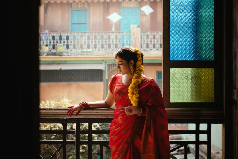 woman in red and yellow cloth standing on balcony