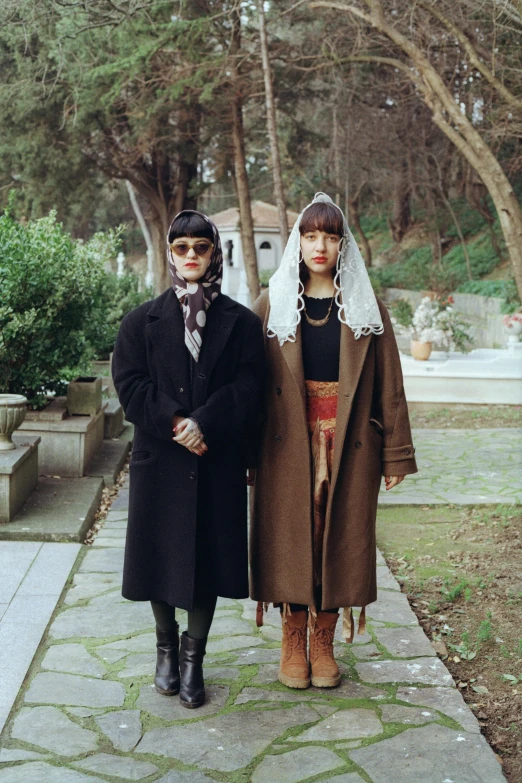 two woman standing outside on a stone path