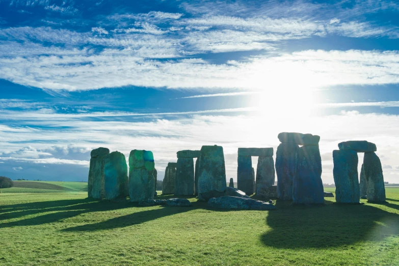 the sun shining on an ancient monument in the field