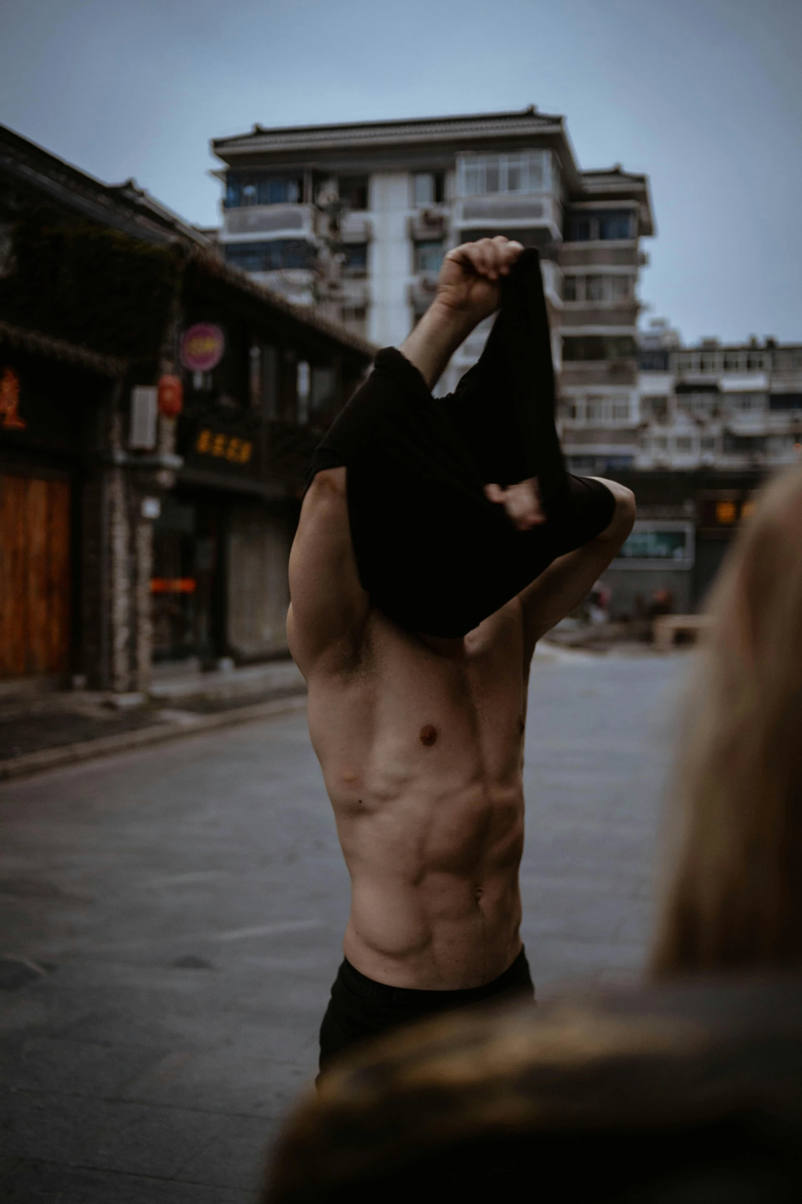 a man without a shirt and hat walking on the street