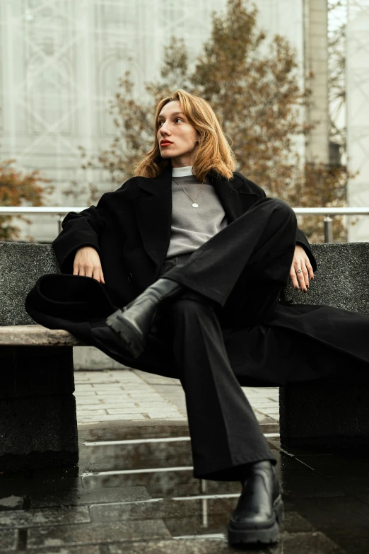 a woman sitting on a bench with her legs crossed