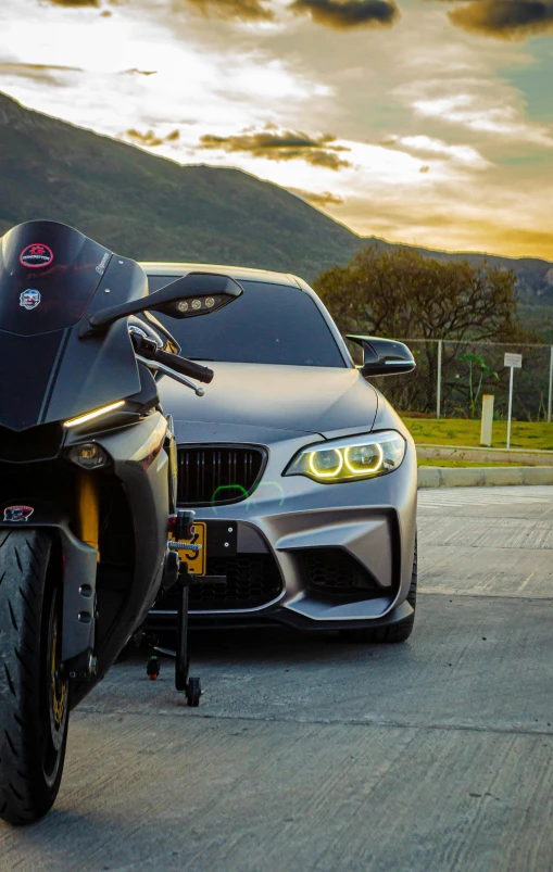 a motorcycle parked near a car near mountains