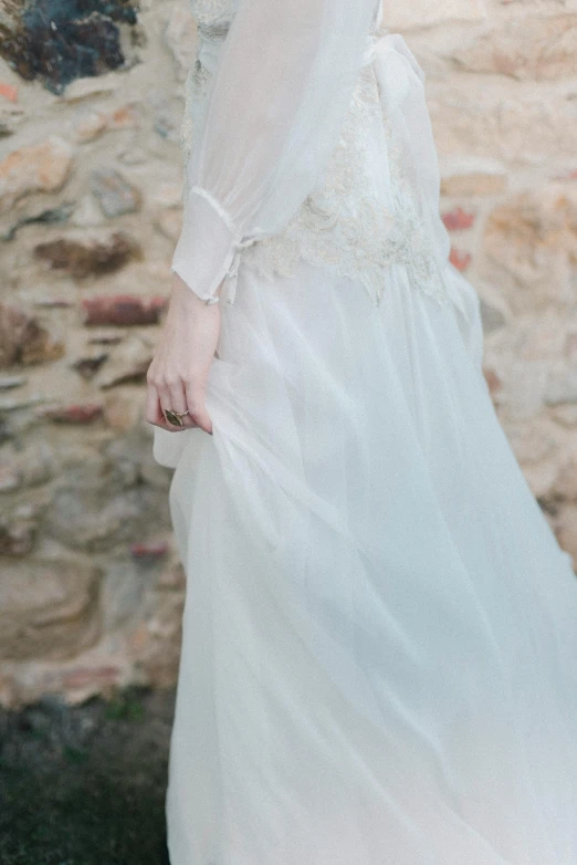 a woman walking down a sidewalk while wearing a dress