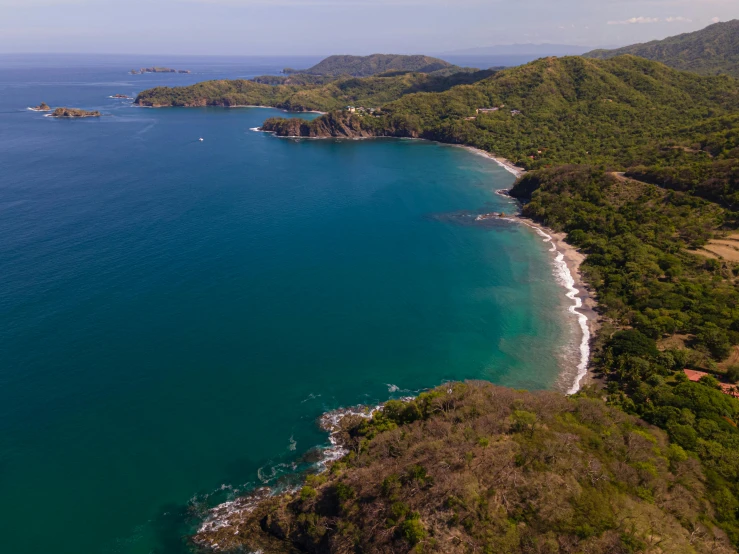 a large body of water next to a lush green hillside