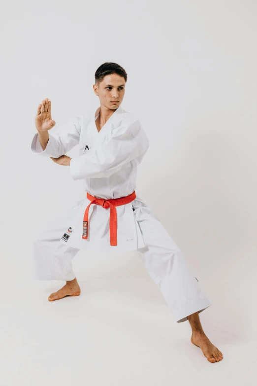 a man in white shirt and pants in karate pose