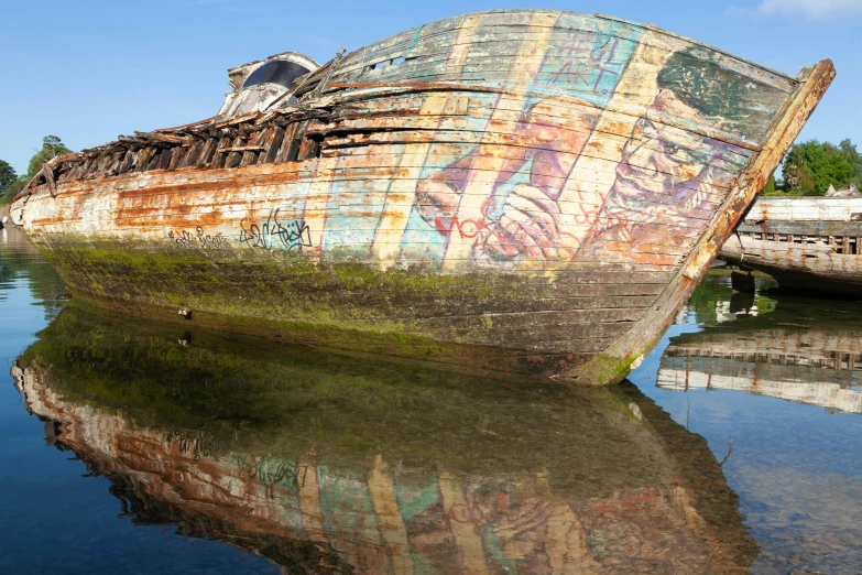 a large, rusty ship with some graffiti on it sitting in the water