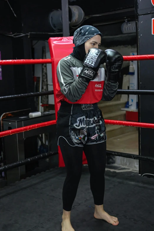 a girl wearing gloves and standing in the ring